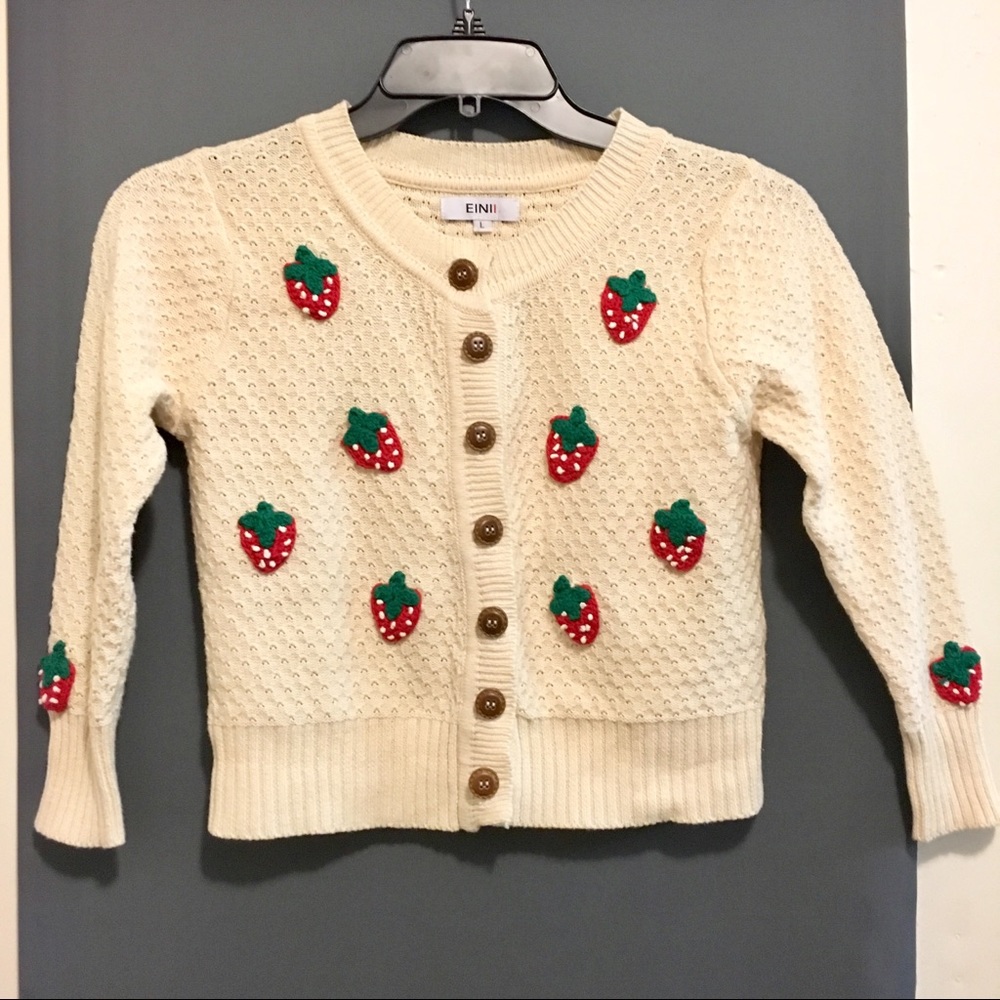 Cropped cardigan with crochet strawberries.
